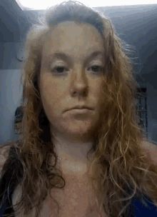a woman with a serious look on her face has wet hair