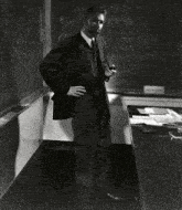 a black and white photo of a man standing next to a bee