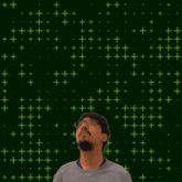 a man stands in front of a green background with stars and the number 12