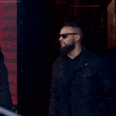 a man in a black suit is walking up stairs