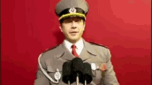 a man in a military uniform stands in front of a microphone