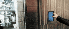 a person is pressing a button on a wall that says ' 12:34 ' on it