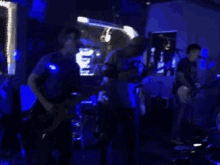 a group of men playing guitars and singing into microphones on a stage
