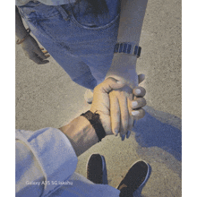 a person holding another person 's hand with the words galaxy a35 5g lakahu above them