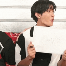 a man is holding a piece of paper that says emily