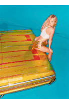 a woman is sitting on the back of a yellow car with red stripes