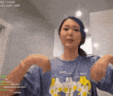a woman wearing a blue shirt with meow written on it
