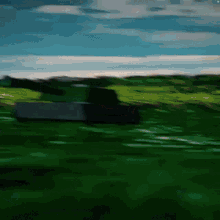 a tank is driving through a grassy field