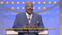 a man in a suit and tie is holding a clipboard and saying your name sounds like