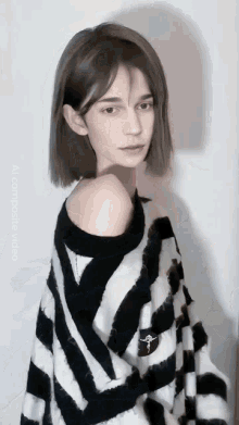 a woman is wearing a black and white striped sweater with the word composite video on the bottom