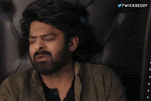 a man is sitting on a couch in front of a twitter logo