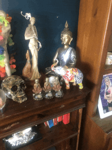 a shelf with a statue of a buddha and a skull
