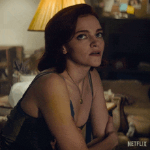 a woman sitting on a couch with a netflix logo on the bottom