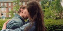 a man and a woman are kissing in front of a netflix building