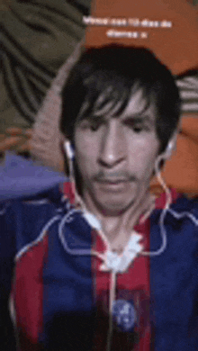 a man wearing headphones and a blue and red striped shirt .