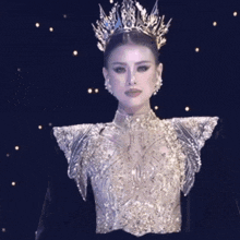 a woman is wearing a crown and a very elaborate dress