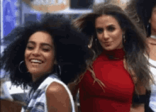 two women are standing next to each other and smiling for the camera .