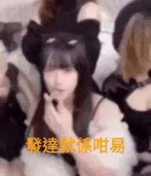 a woman wearing a cat ear hat with chinese writing behind her