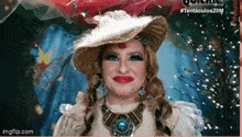 a woman is wearing a hat and a necklace and smiling