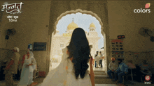 a woman in a white dress stands in front of a building with the words colors written on the bottom