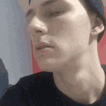 a close up of a man 's face wearing a hat and a black shirt