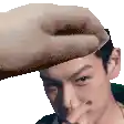 a man is covering his nose with his hand while a hand is holding his head .