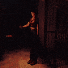 a woman standing in a dark room holding a torch