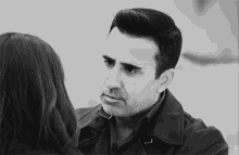 a man and a woman are kissing in a black and white photo .