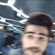 a blurry picture of a man 's face with a beard and glasses .