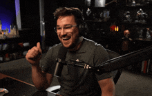 a man giving a thumbs up in front of a microphone with the words " two thumbs up " below him