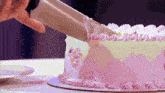 a person is cutting a cake with a knife on a table