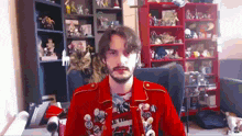 a man in a red jacket is sitting in a chair