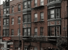 a brick building with a fire escape and a sign that says ' nsn ' on it