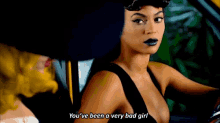 a woman in a black dress is driving a car and says `` you 've been a very bad girl '' .