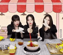 three women are preparing food in front of a sign that says a on it