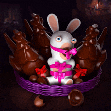 a rabbit with a pink bow around its mouth sits in a basket of chocolate eggs
