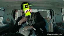 a gif of a man in a car with mayhemgifs.com at the bottom of the screen