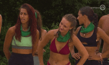 a group of women wearing bikinis and green scarves are standing in front of a sign that says premijera