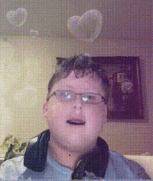 a young boy wearing glasses and headphones looks at the camera