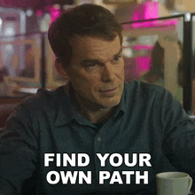 a man sits at a table with the words find your own path written on the bottom