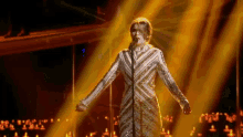 a woman is singing into a microphone on a stage with candles in the background .