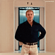 a man standing in front of an elevator with the letter a on the door
