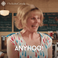 a woman in a colorful shirt is making a funny face and saying anyhoo