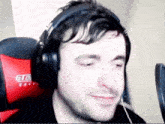 a man wearing headphones is sitting in a chair that says gto race
