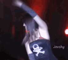 a woman wearing a skull and crossbones shirt is dancing on stage .