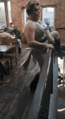 a man standing on a railing in a restaurant