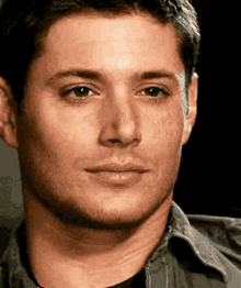 a close up of a man 's face with his eyes closed and a smile on his face .