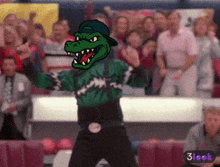 a cartoon drawing of a crocodile mascot with a crowd in the background