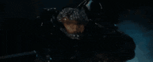 a close up of a monster in the dark with a blue light behind it