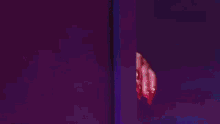 a woman with blue hair is peeking out from behind a wall in a dark room .